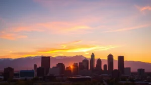 Denver skyline at sunset with Rocky Mountains in background, golden hour light reflecting off downtown buildings, vibrant urban landscape photography