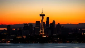 Seattle Space Needle and downtown skyline with Puget Sound water in foreground during golden hour sunset, vibrant city lights beginning to illuminate, Pacific Northwest landscape