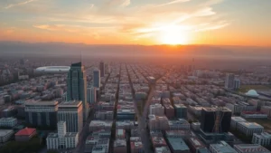 Aerial view of Tehran cityscape at sunset with Alborz Mountains in background, urban landscape with mix of modern and traditional architecture, golden hour lighting, wide-angle perspective showing sprawling city