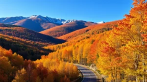 White Mountains of New Hampshire with autumn foliage and a winding mountain road through dense forest, golden and orange leaves covering trees, clear blue sky, photorealistic landscape photography