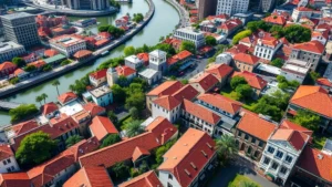 Aerial view of New Orleans French Quarter with Mississippi River bend, historic buildings with red tile roofs, green courtyards, natural light, daytime cityscape